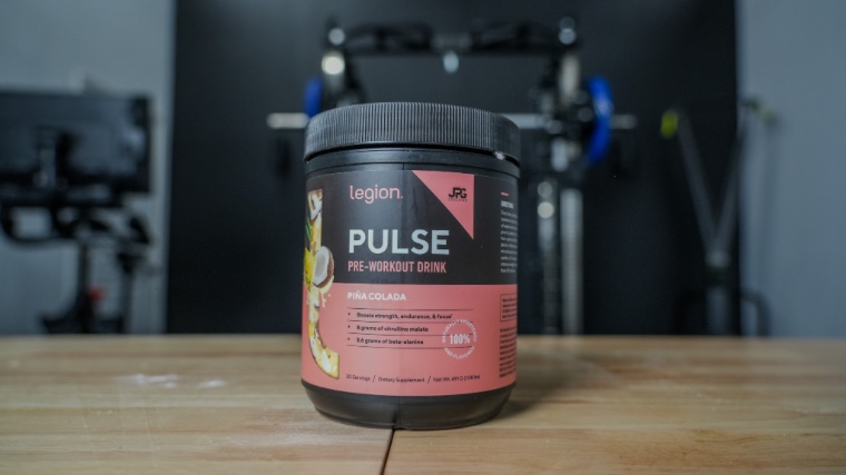 Container of Legion Pulse Pre-Workout on wooden table.