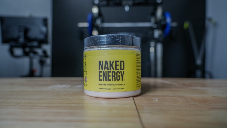Container of Naked Nutrition Pre-Workout on wooden table.