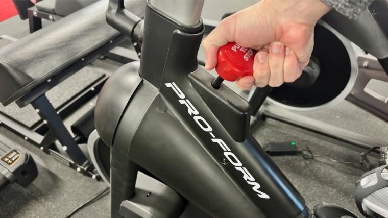 BarBend reviews writer Matt Cummings adjusting the resistance knob on the ProForm Carbon CX.