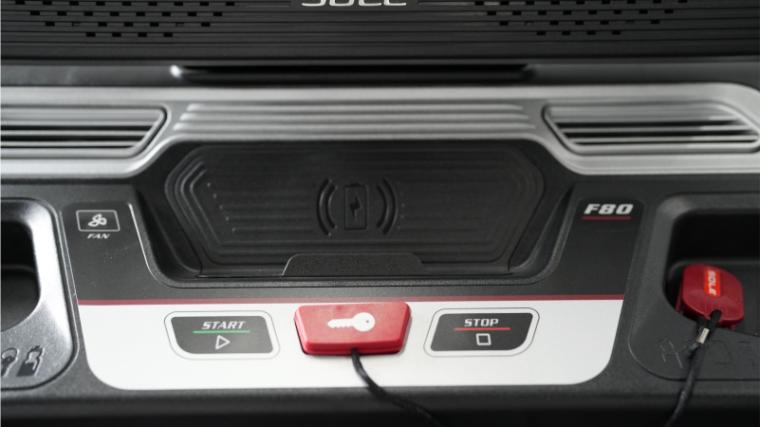 The wireless charging pad, emergency key, and start and stop buttons on Sole F80 — identical to the Sole ST90.