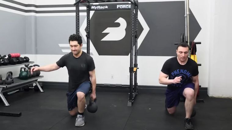 Two people working out with kettlebells.